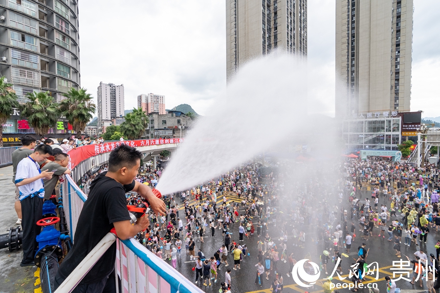 2025德江“水龙节”活动现场，工作人员为参加活动的市民游客洒水助兴。人民网记者 涂敏摄