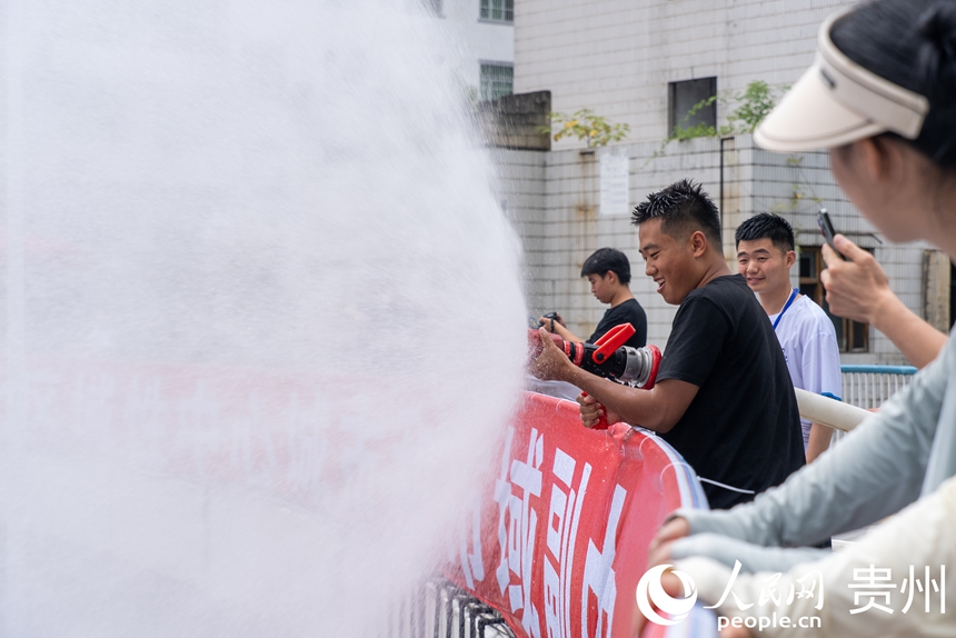 2025德江“水龙节”活动现场，工作人员为参加活动的市民游客洒水助兴。人民网记者 涂敏摄