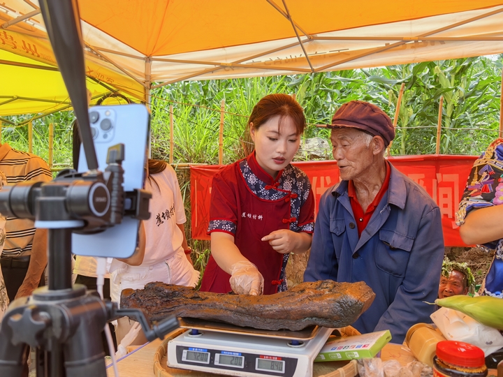 图为“村抖”现场助农主播直播销售腊肉。邹琴印摄.jpg