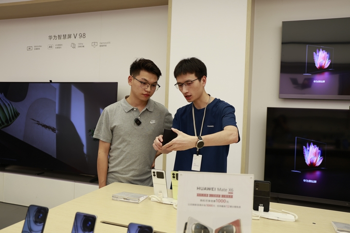 手機商店工作人員向市民介紹“國補”政策.JPG