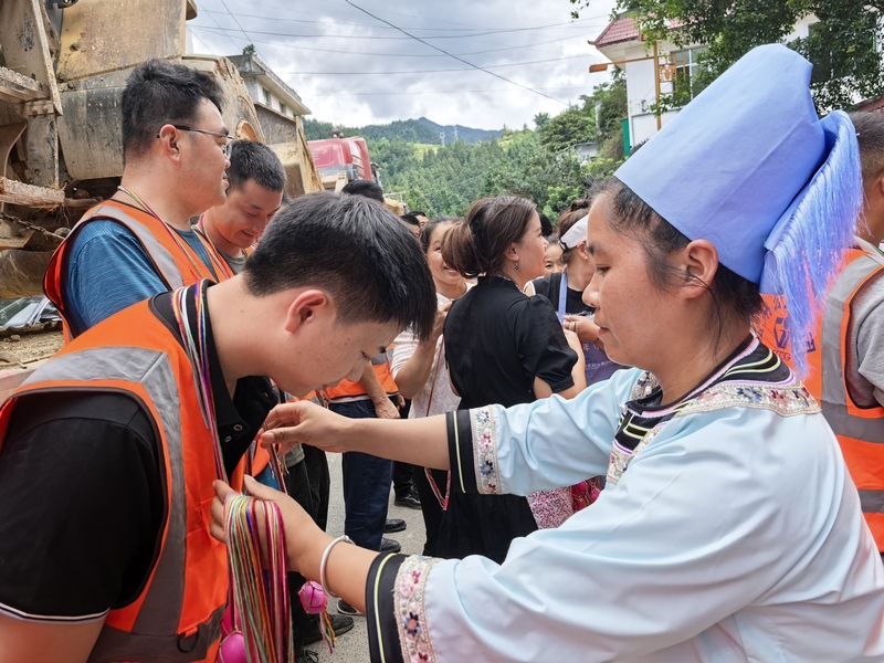 村民们将精心准备的红鸡蛋送到每一位突击队员手中。