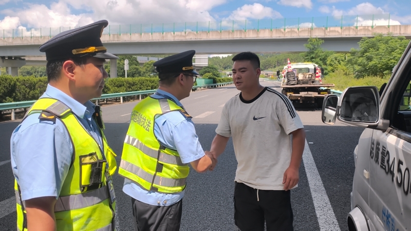  救災物資運輸駕駛員緊握執法人員之手，神情滿是感動。