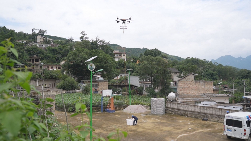 無人機在山間吊運鎮寧蜂糖李。