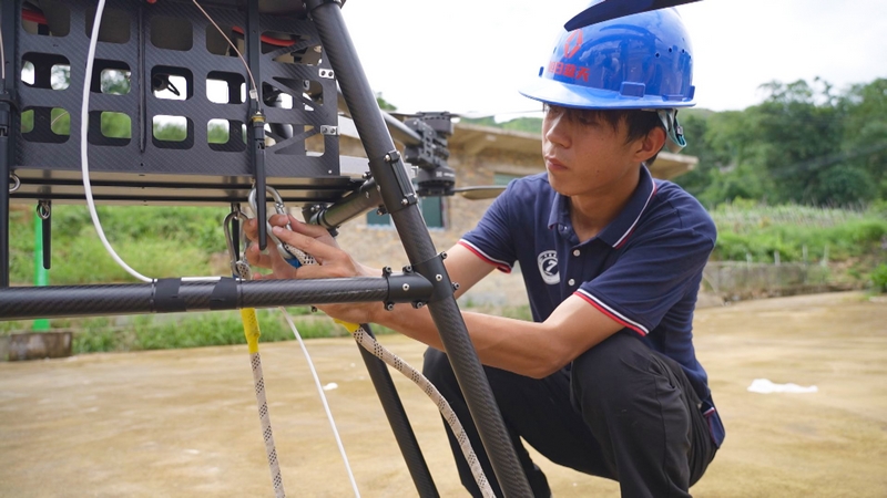 工作人員調試吊運無人機。