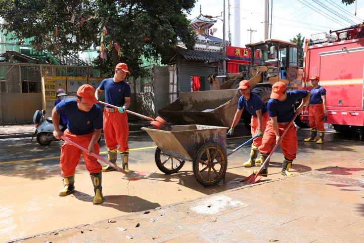 刘元欢与队友们在清理路面积水。（岑光柱  摄）.jpg