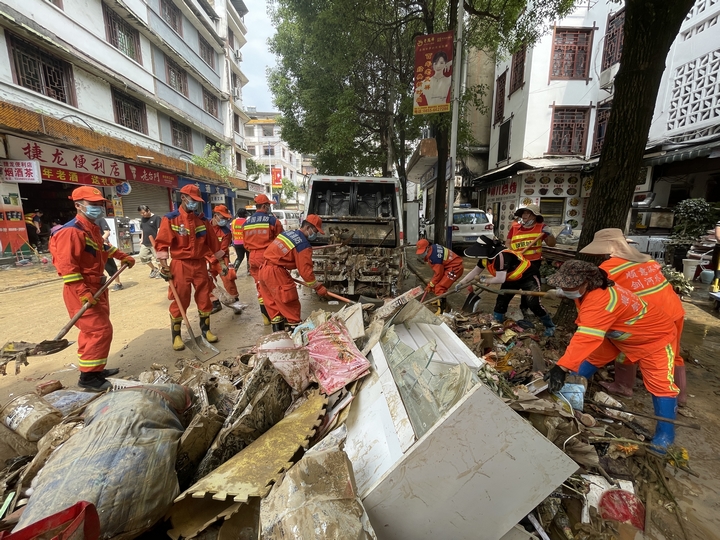 剑河县消防救援大队队员与环卫工人一道清理路边垃圾。