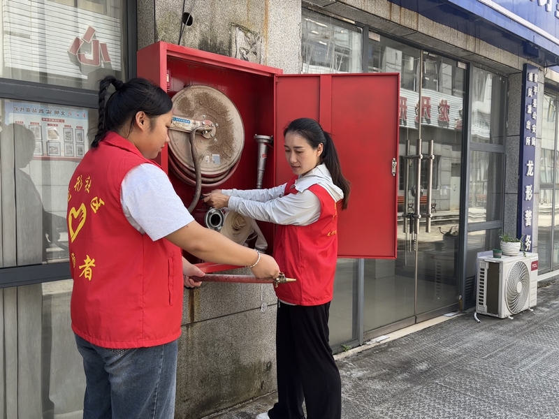 手把手教居民使用灭火器。