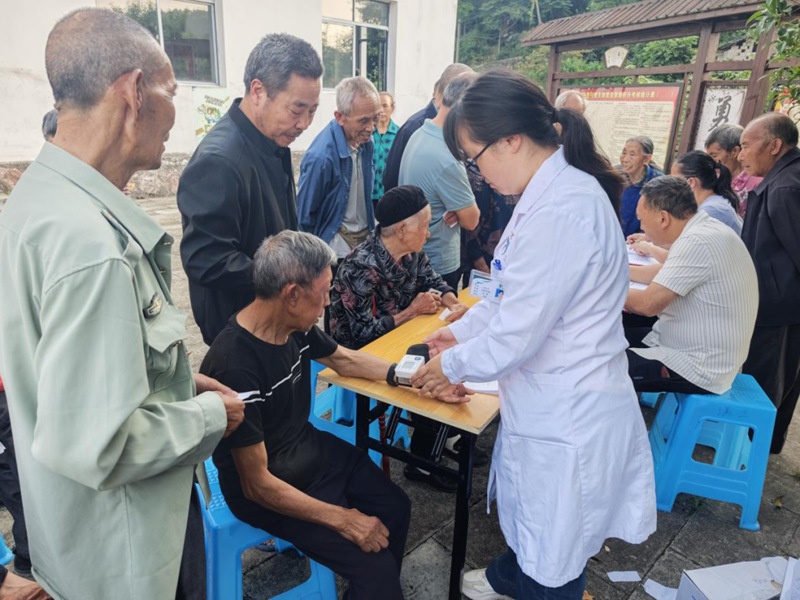息烽县温泉镇卫生院医疗团队正在为温泉镇兴隆村60岁以上老人开展免费健康体检。