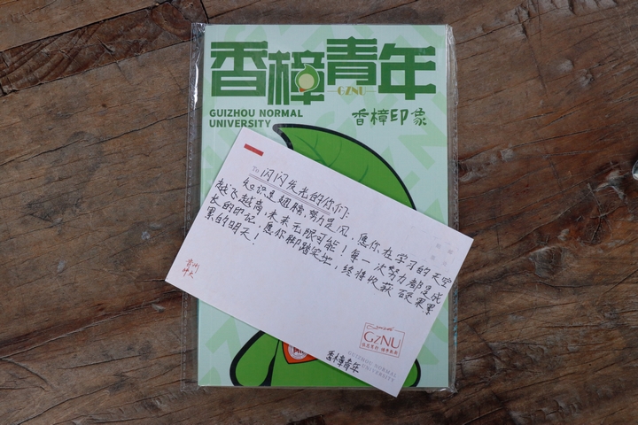 貴州師范大學實踐隊成員給肇興中學同學帶來的印有“香樟青年”LOGO的筆記本以及親筆書寫的明信片。.jpg