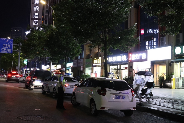 交警引导市民在路边临时停车位停车。张弘扬 摄.jpg