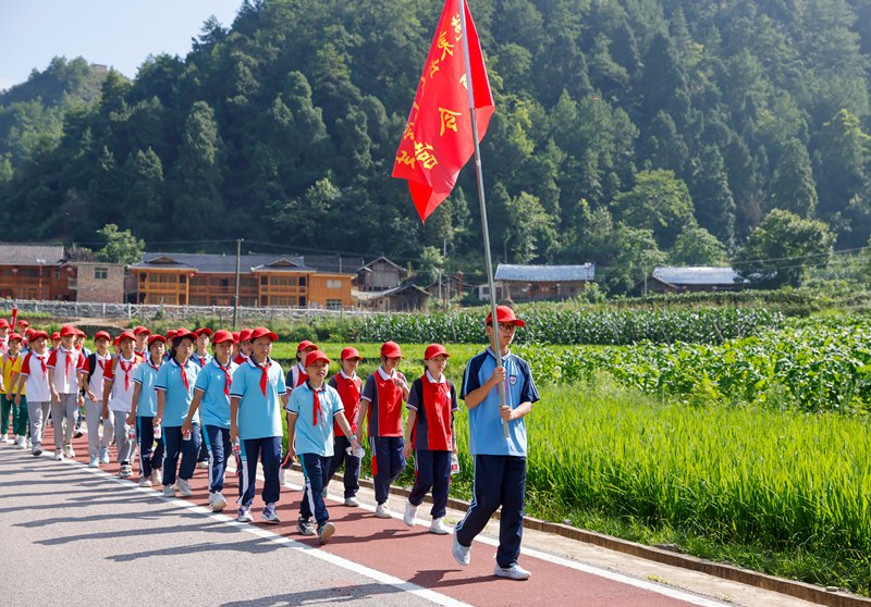 学生在贵州省黔东南苗族侗族自治州施秉县黑冲红色革命教育基地重走长征路。