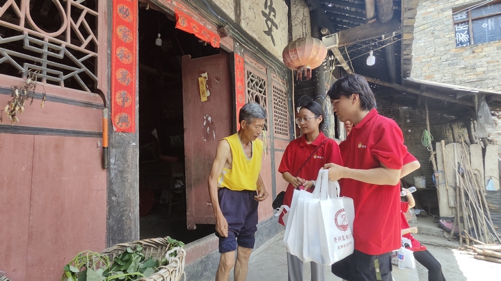 实践团到村里开展送医活动。陈丽摄.jpg