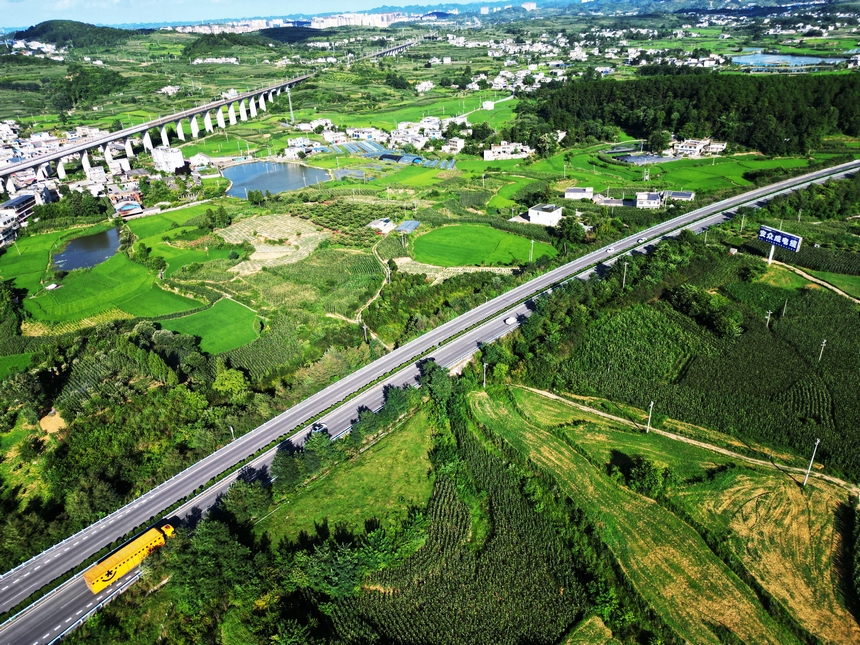 2025年7月20日，夏日的贵州省黔西市林泉镇合心村，高速公路与田园、村居、远山相映成景，乡村如画。 