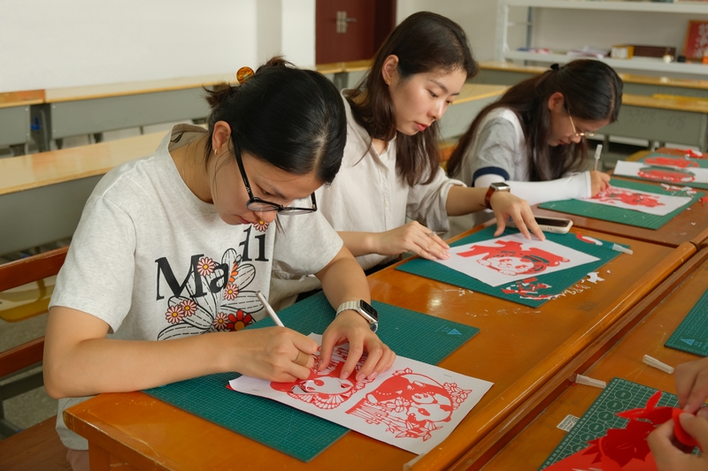 师生们在社团活动室创作剪纸作品。