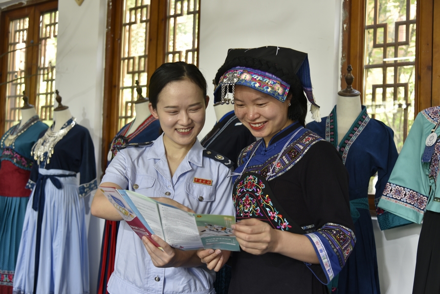 火把節期間，晴隆縣稅務人員走進“布依垚”服飾商鋪，為企業送去“稅費大禮包”，講解稅費政策。劉湘攝