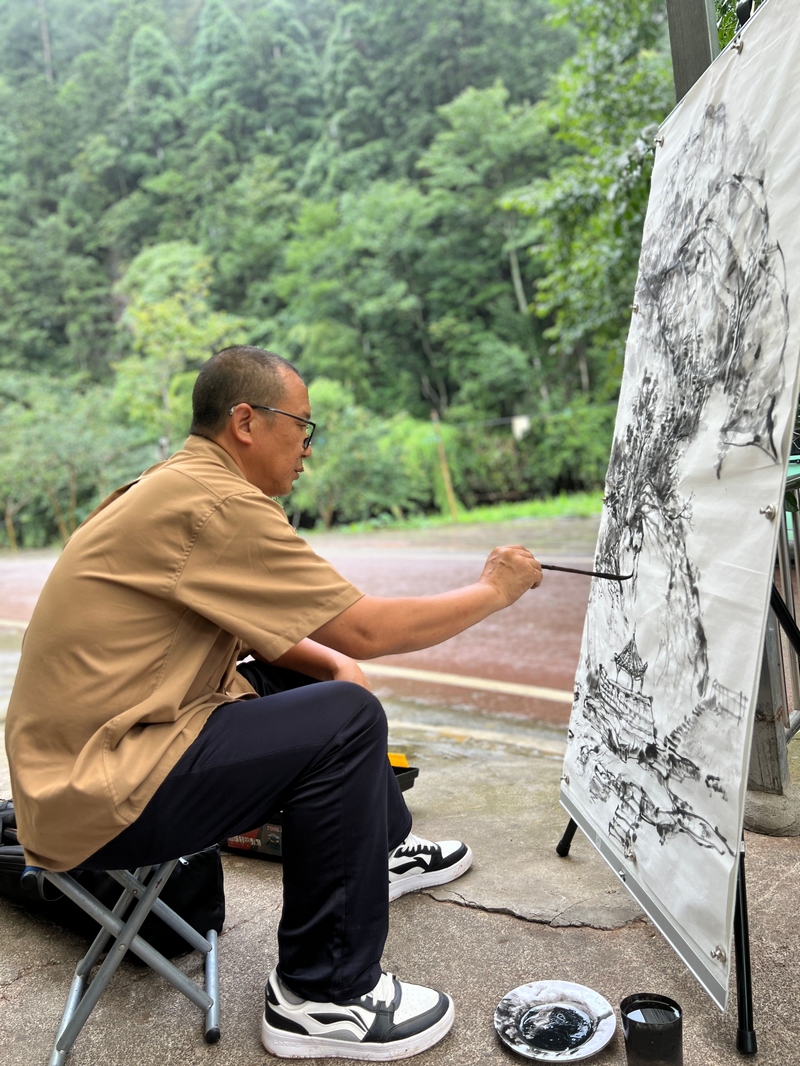 中国画作品创作，以墨色勾勒丹霞谷山水轮廓。习水县融媒体中心供图