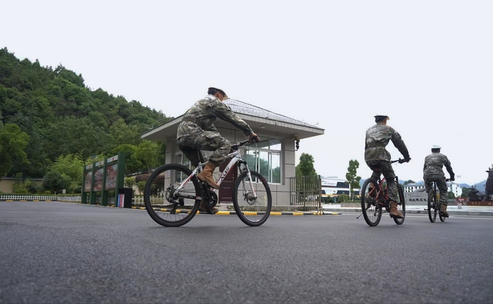 武警战士骑着自行车沿大坝疾驰。.jpg
