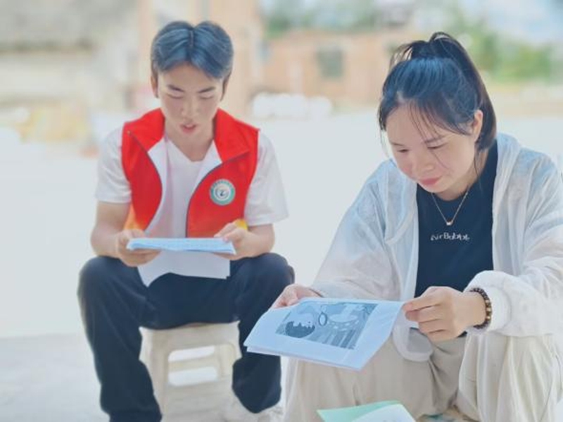 图为志愿者在为群众宣讲活动内容。