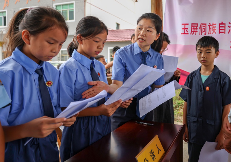 驻村干部志愿者在指导小朋友认识地图。