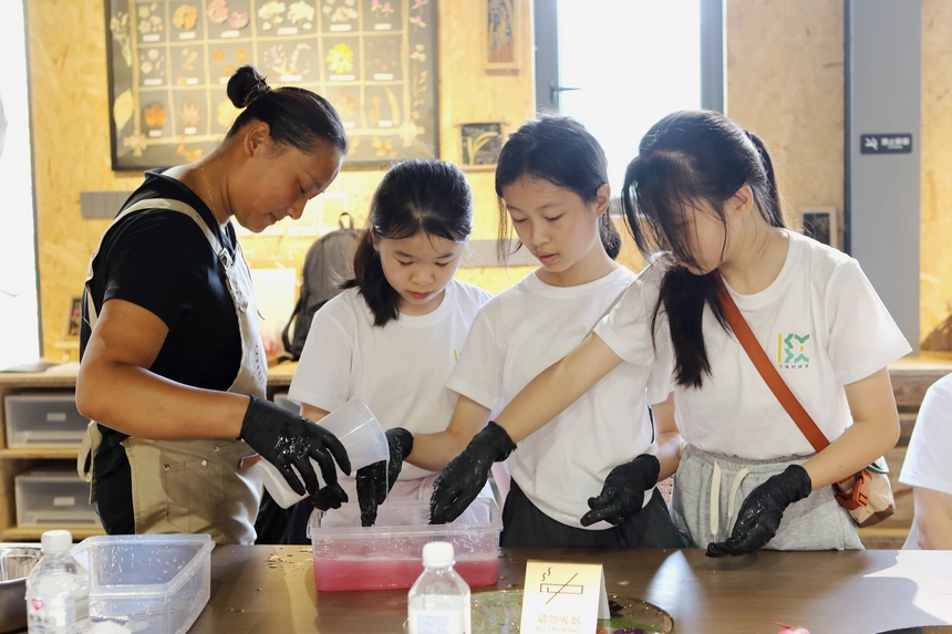 來自上海的孩子在工作人員的帶領下體驗制作火龍果冰涼粉。