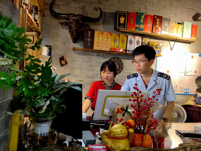 桐梓县税务局工作人员上门辅导纳税人电子税务局操作。娄亚会摄
