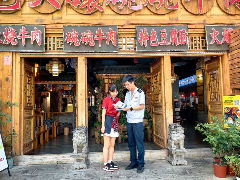 桐梓县税务局工作人员向纳税人宣传税收优惠政策。娄亚会摄