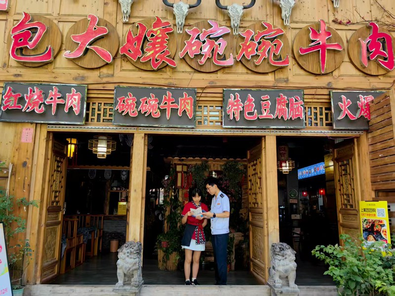 桐梓县税务局工作人员向纳税人宣传税收优惠政策。娄亚会摄