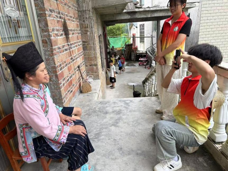 图为志愿服务队员调研完帮村民拍照。