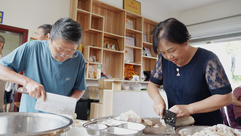 來自四川宜賓長寧的游客正在片白肉。郝濱攝。