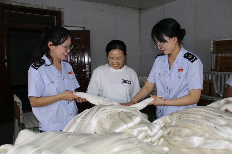 图为税务干部到贵州丝路兴蚕纺织有限公司走访调研，查看企业生产经营情况。邓萍摄