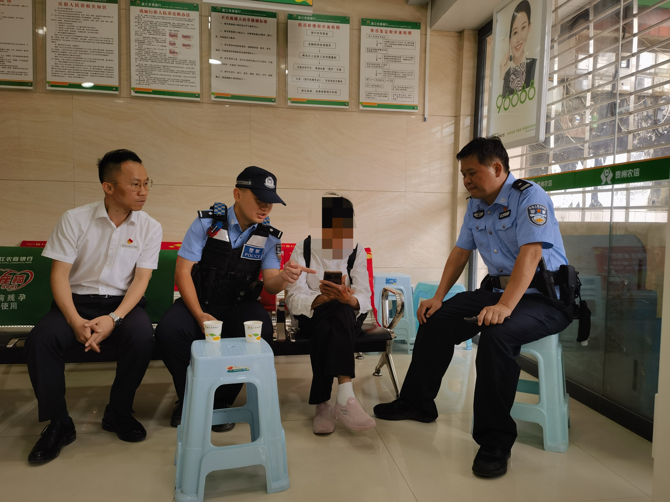 民警及银行工作人员对刘奶奶进行劝阻。麻江农商银行给供图