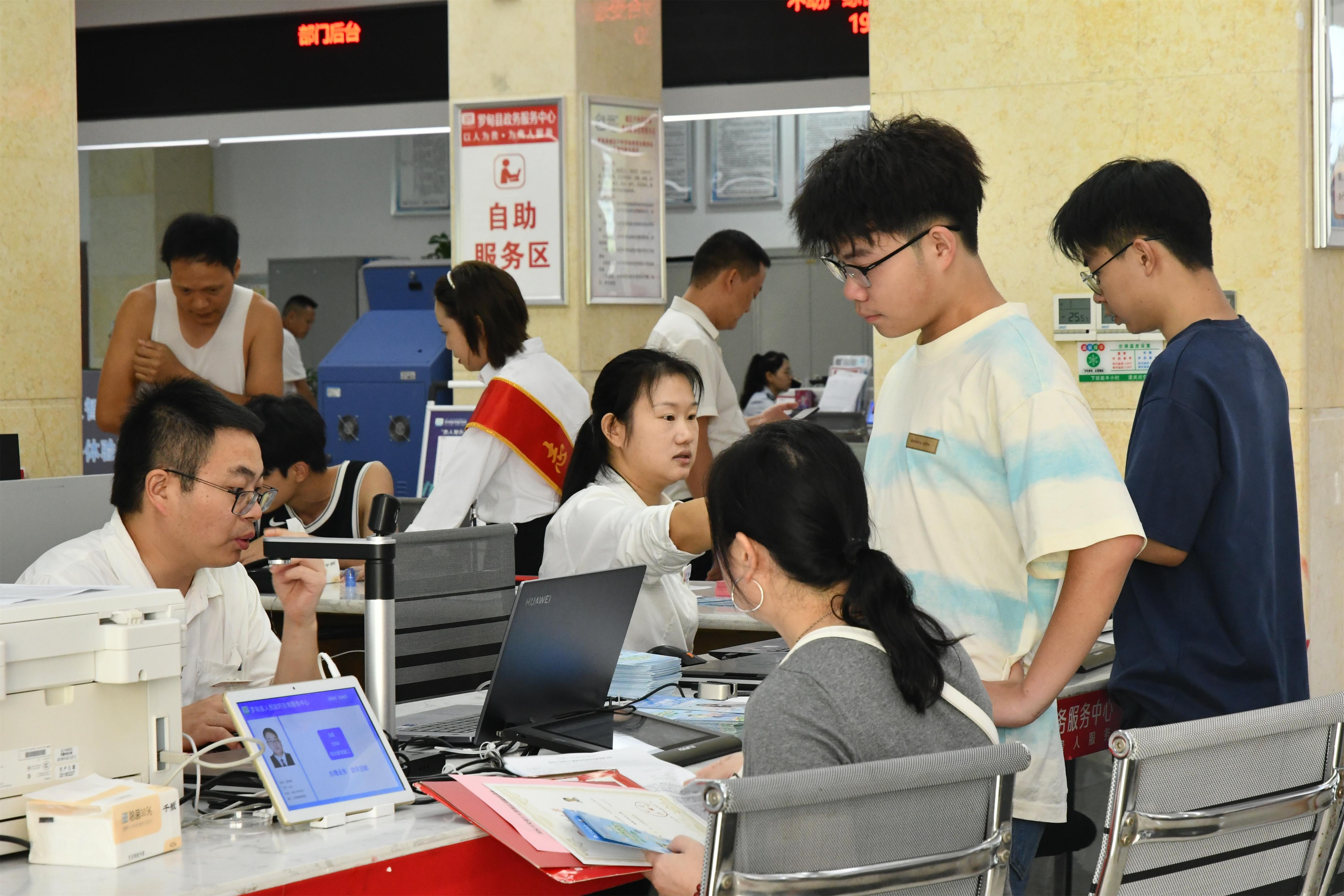 准大学生们与家长在窗口办理生源地信用助学贷款。
