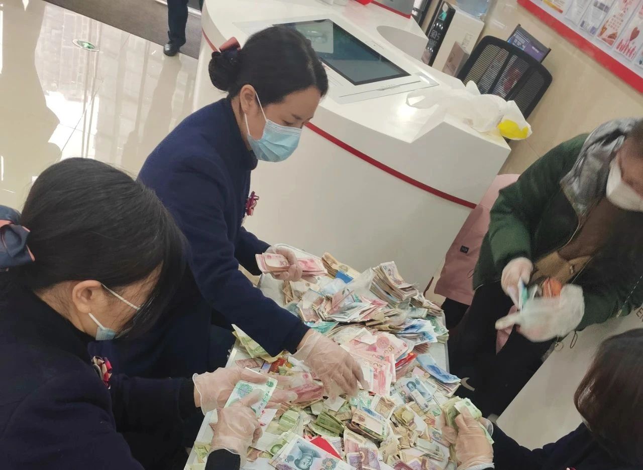 貴州銀行工作人員為顧客清點零鈔。