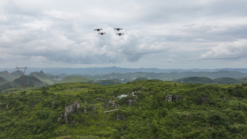 四架重載無人機騰空而起，僅用4分鐘便將374公斤塔材從山腳塔材堆放地運送到山頂目的地。陳炎攝.JPG