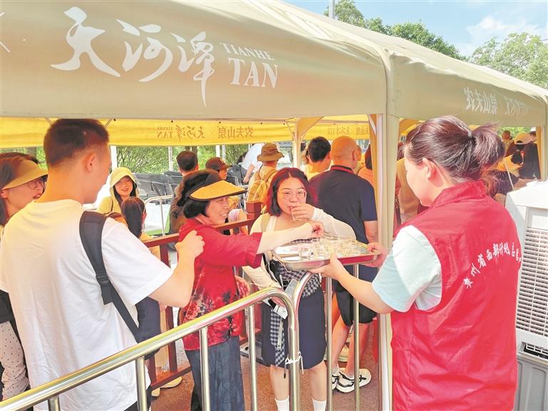 在贵阳市天河潭景区,“小青爽”志愿者服务游客。 肖知潞摄