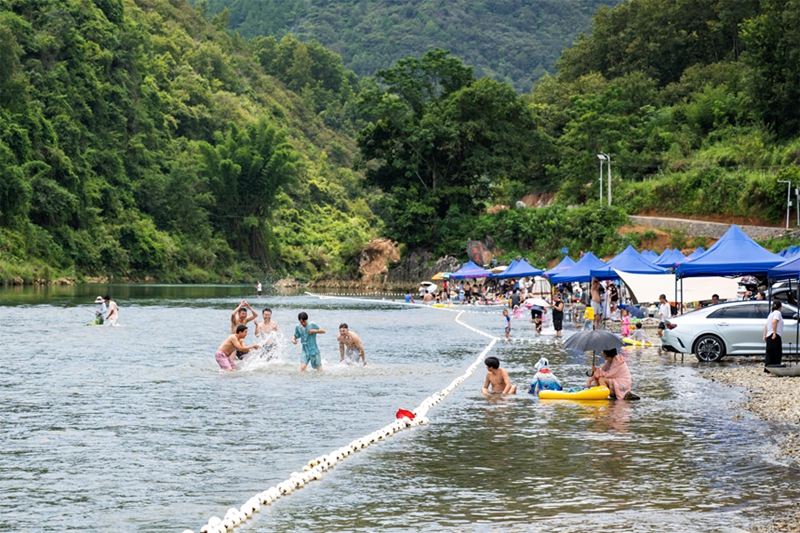 游客在罗甸县龙坪镇新艾村新艾滩游玩。