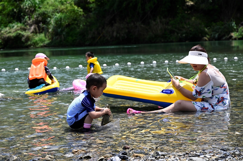 游客在罗甸县龙坪镇新艾村新艾滩游玩。