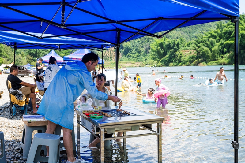 游客在罗甸县龙坪镇新艾村新艾滩游玩。