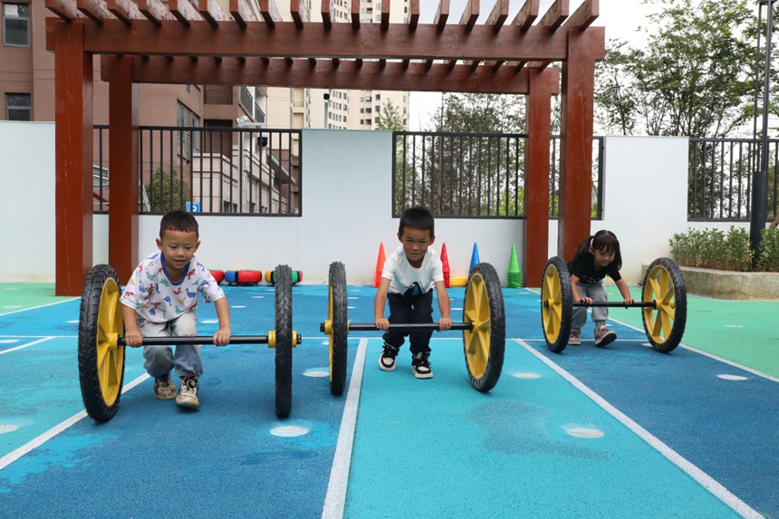 报名的幼儿正在进行户外游戏。