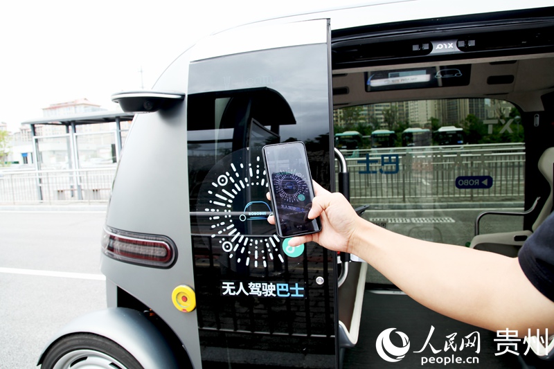 在花溪大学城无人驾驶公交站，乘客正打算扫码乘车。人民网记者 王秀芳摄