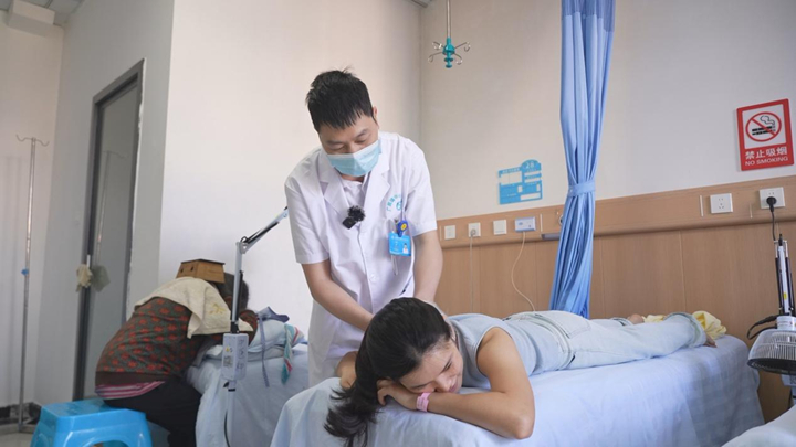 长顺县广顺镇中心卫生院中医科医生为患者进行中医理疗。