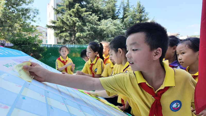 在金沙县第二小学，孩子们将写满心愿的卡片郑重贴上梦想板。胡凤至 摄.jpg