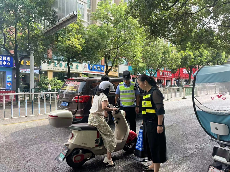 工作人员与民警给车主普及交通安全知识.jpg