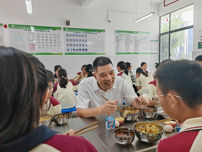 陪餐人员与学生一同用餐，关注餐食情况。谢永恒  摄.jpg