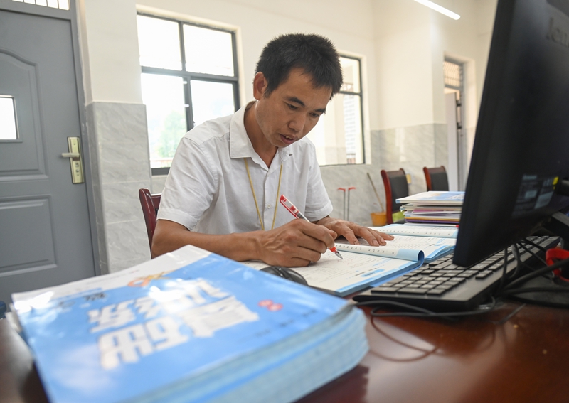 9月5日，松桃苗族自治县迓驾镇教师任达兵在批改作业。谢慧芳摄