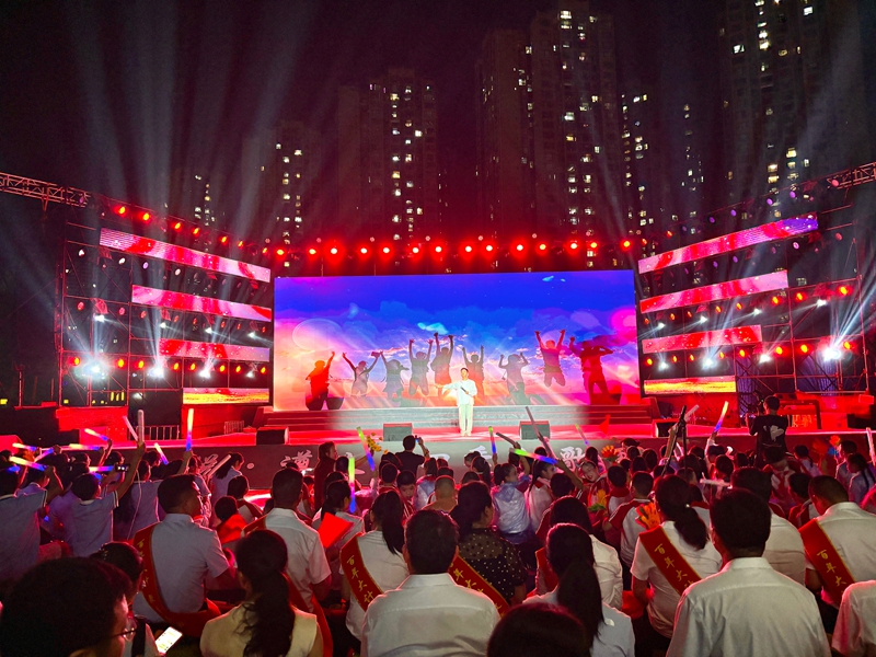 舞台上表演者在绚丽背景与灯光下倾情演出，台下观众热情高涨，氛围热烈。张川 摄.jpg