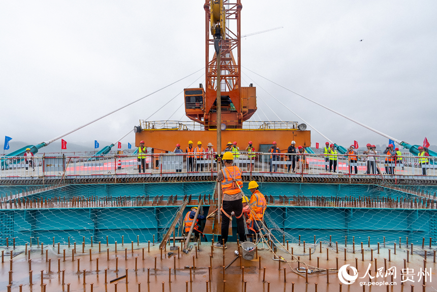 建设者正在安装大桥的最后一片小纵梁。人民网记者 涂敏摄