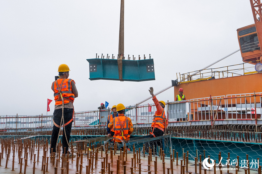 建設者正在吊裝大橋的最后一片小縱梁。人民網記者 涂敏攝