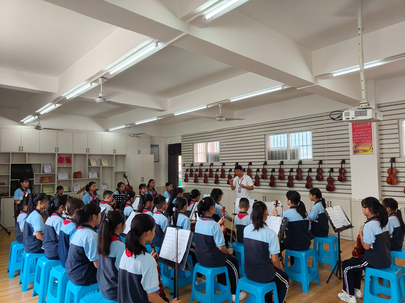 学生们正在专心听老师讲解小提琴知识。蔡昀 摄.jpg