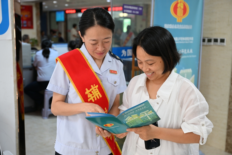 龙里县税务局干部向群众讲解公平竞争相关政策.JPG